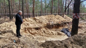 Cầu nguyện trước ngôi mộ tập thể ở Ucraina